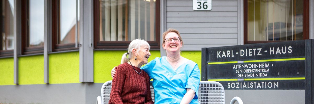 Foto Pflegerin und Senioren vor dem Karl-Dietz-Haus