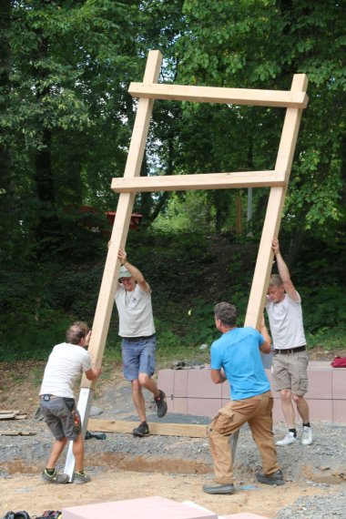 Die Männer der Firma Projekt Spielart stemmen die Balken für den einen Spielturm in die Höhe