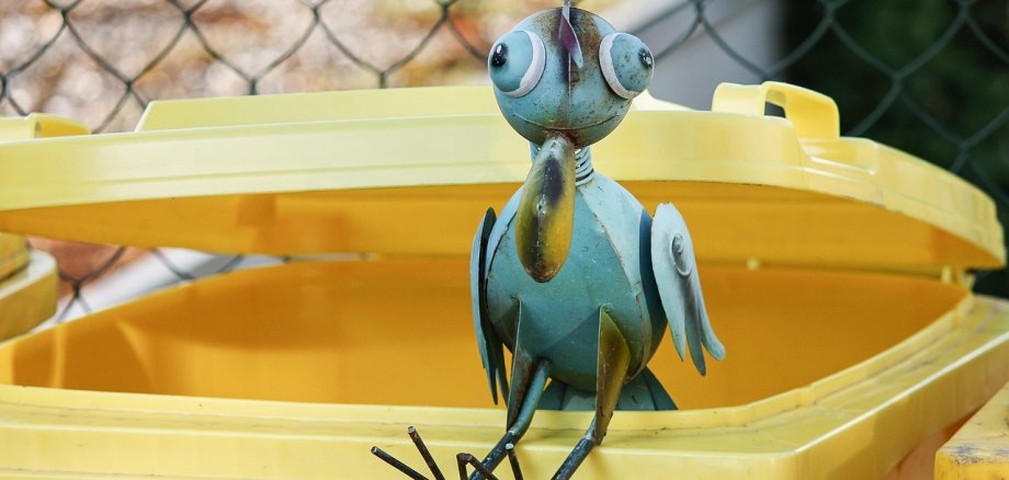 Foto Gelbe Tonne und Metalvogel