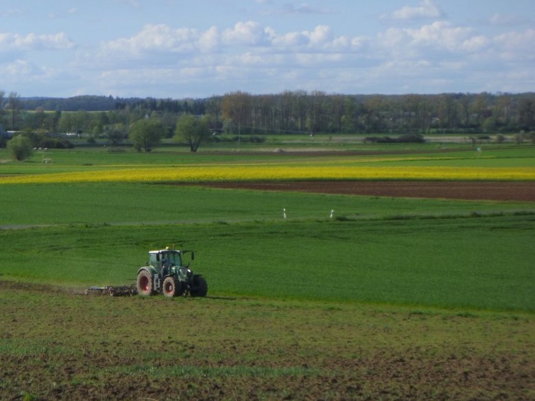 Foto: Landwirt mit Traktur bei der Bodenbearbeitung